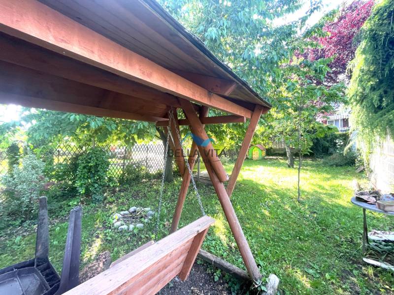 Drevená záhradná hojdačka a stromy v záhrade na Nemocničnej ulici v Galante.