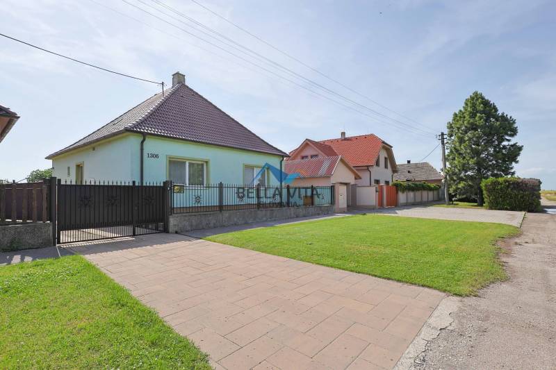 Rodinné domy na Hodskej ulici v Galante s upravenými záhradami a chodníkom.