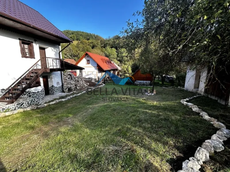 Rodinný dom v Čiernej Lehote  obklopený záhradou a zeleňou, slnečný deň.