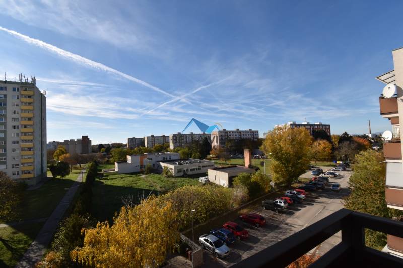 Výhľad na okolie z balkóna v Štvrti SNP v Galante, s parkoviskom a zeleňou.