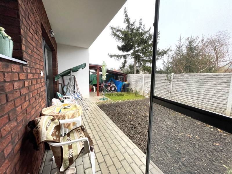 Terasa rodinného domu s hojdačkou a s výhľadom na záhradu na Hlavnej ulici v Mostovej.