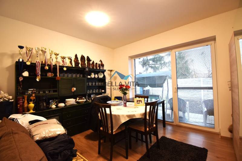 Jedáleň v rodinnom dome s vitrínou, stolom, stoličkami a podlahou s dreveným dekorom.