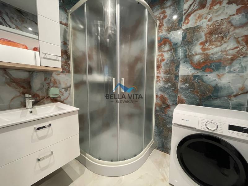 Kúpeľňa v 3-izbovom byte s moderným sprchovým kútom a práčkou.