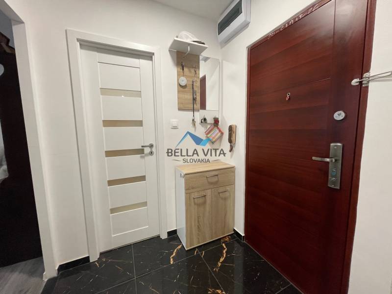 Vstupná hala v 3-izbovom byte s tmavou dlažbou a bielymi dverami.