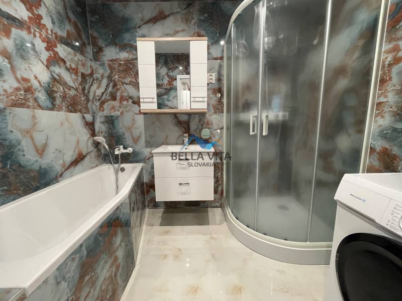 Kúpeľňa 3-izbového bytu s vaňou, sprchovým kútom a práčkou.