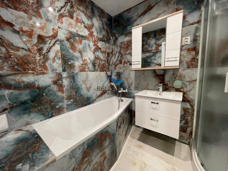 Kúpeľňa v 3-izbovom byte s mramorovým obkladom a vaňou.