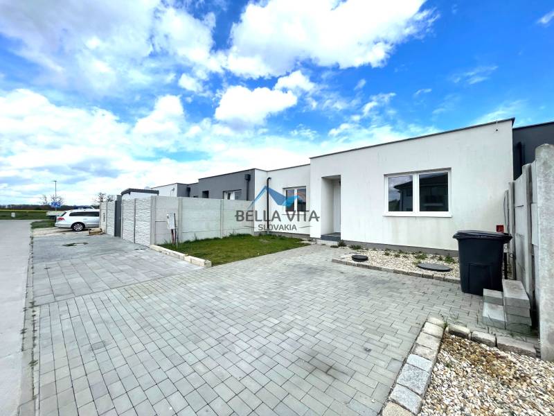 Rodinný dom v Ekoosade, Veľké Úľany, s jednoduchou fasádou a spevnenou príjazdovou cestou.