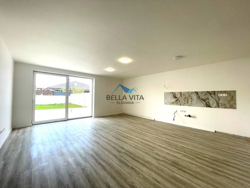 Obývacia izba s veľkým oknom a podlahou s dreveným dekorom v Rodinnom dome.