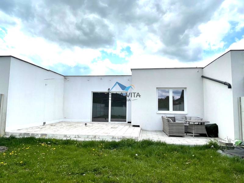 Rodinný dom vo Veľkých Úľanoch na ulici Ekoosada s terasou a záhradným nábytkom.