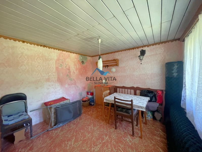 Staršie zariadená izba so stolom, stoličkami a podlahou s dreveným dekorom.
