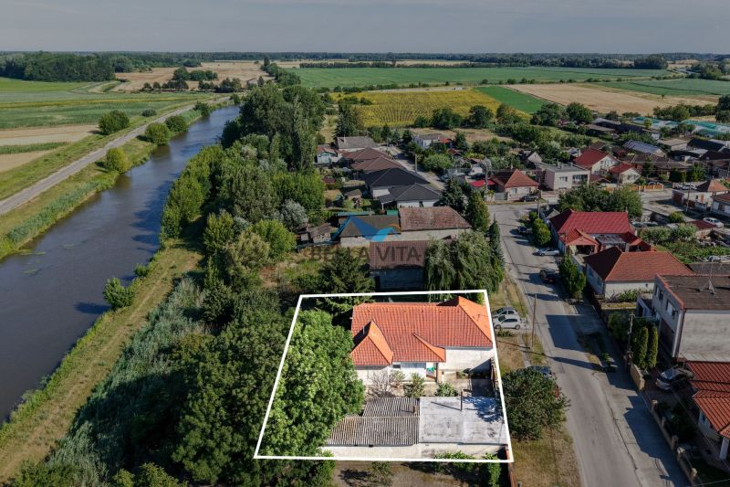 Rodinný dom v Čiernej Vode na Čiernej Vode pri rieke obklopený zeleňou a susednými domami.