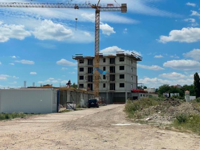Stavenisko s rozostavaným bytovým domom, žeriavom a stavebným materiálom na Šalskej ulici v Galante.