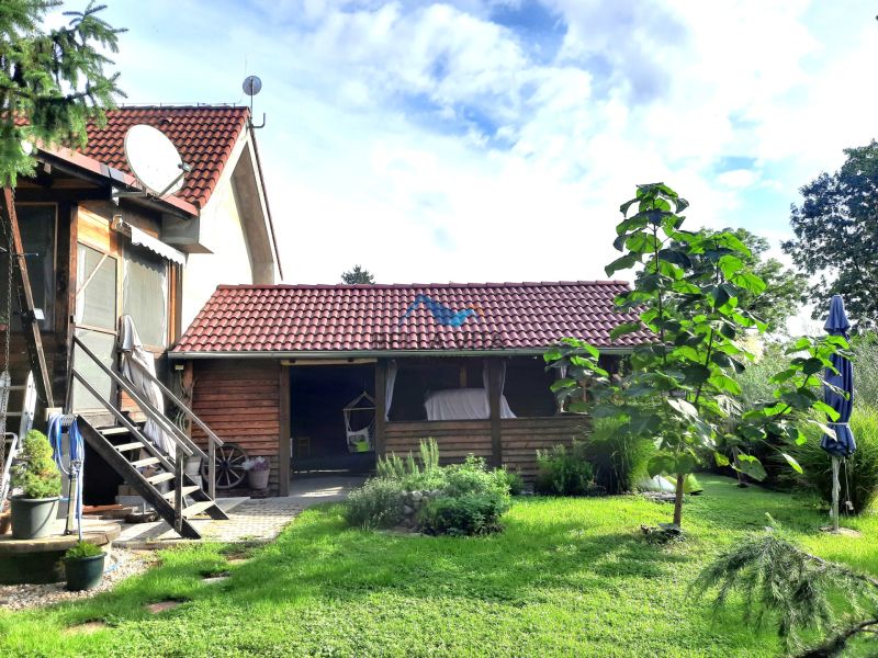 Záhrada rodinného domu v Šoporni s terasou a zeleným trávnikom.