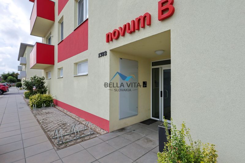 Vchod bytového domu na ulici Trstice, Trstice s výraznými červenými balkónmi.